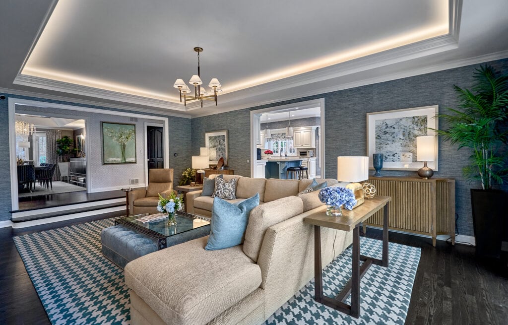 Living room with beige sofa, patterned rug, and open doorway.
